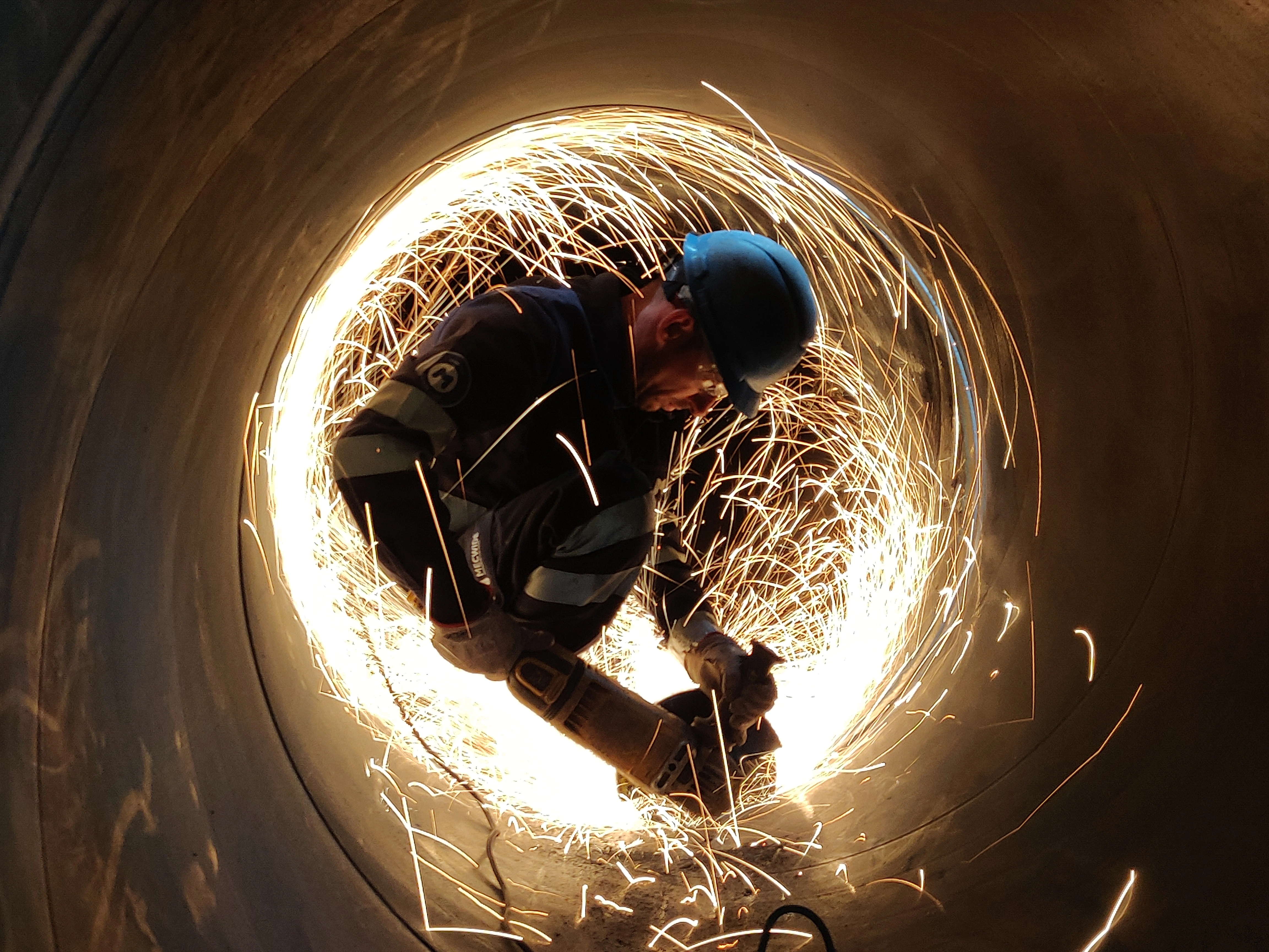 Trabalhador em obra com faíscas de soldadura